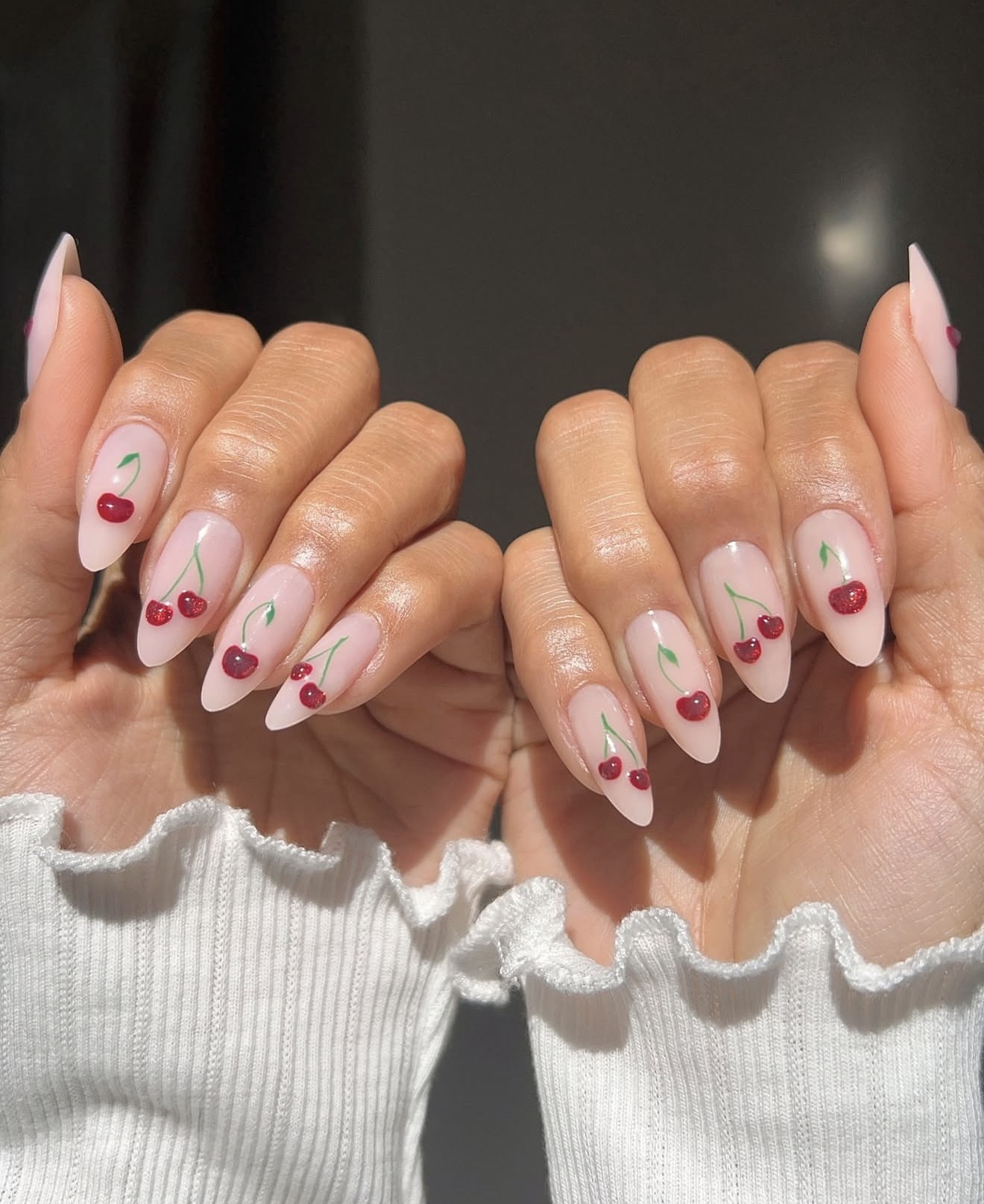 Glossy Cherry Red Almond Nails with Sparkle Accents
