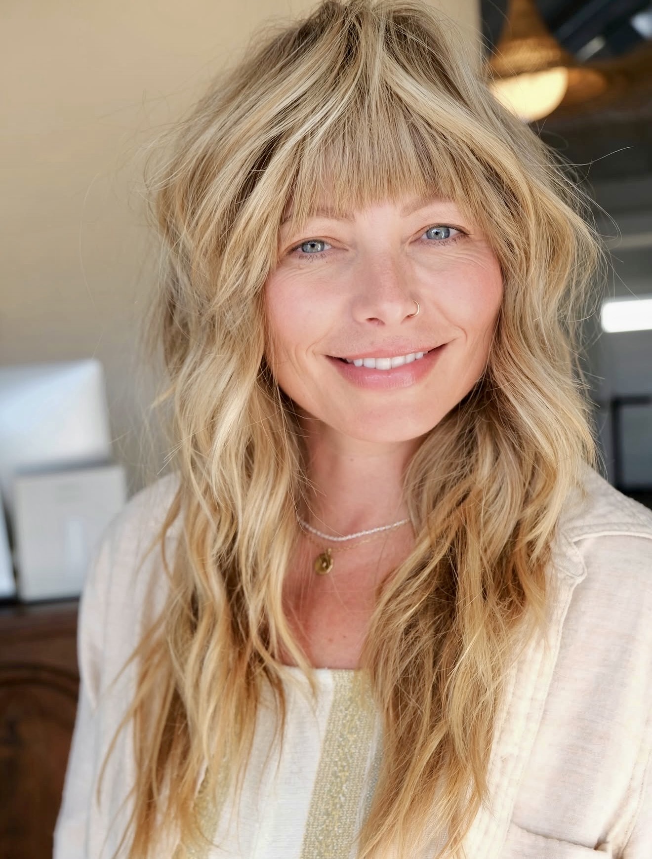 Shaggy Layers With Blunt Bangs And Sun-Kissed Blonde