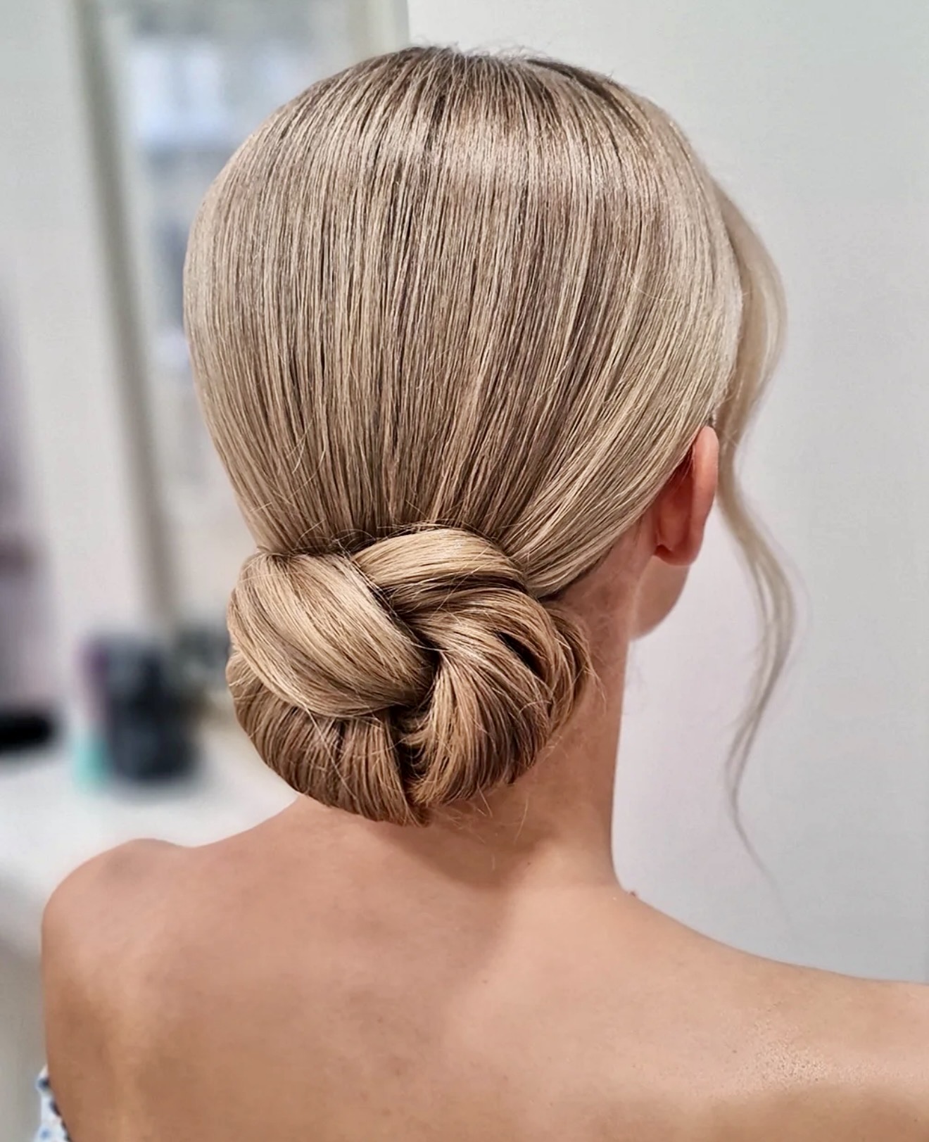 Sleek Braided Low Bun With Wispy Face-Framing Strands