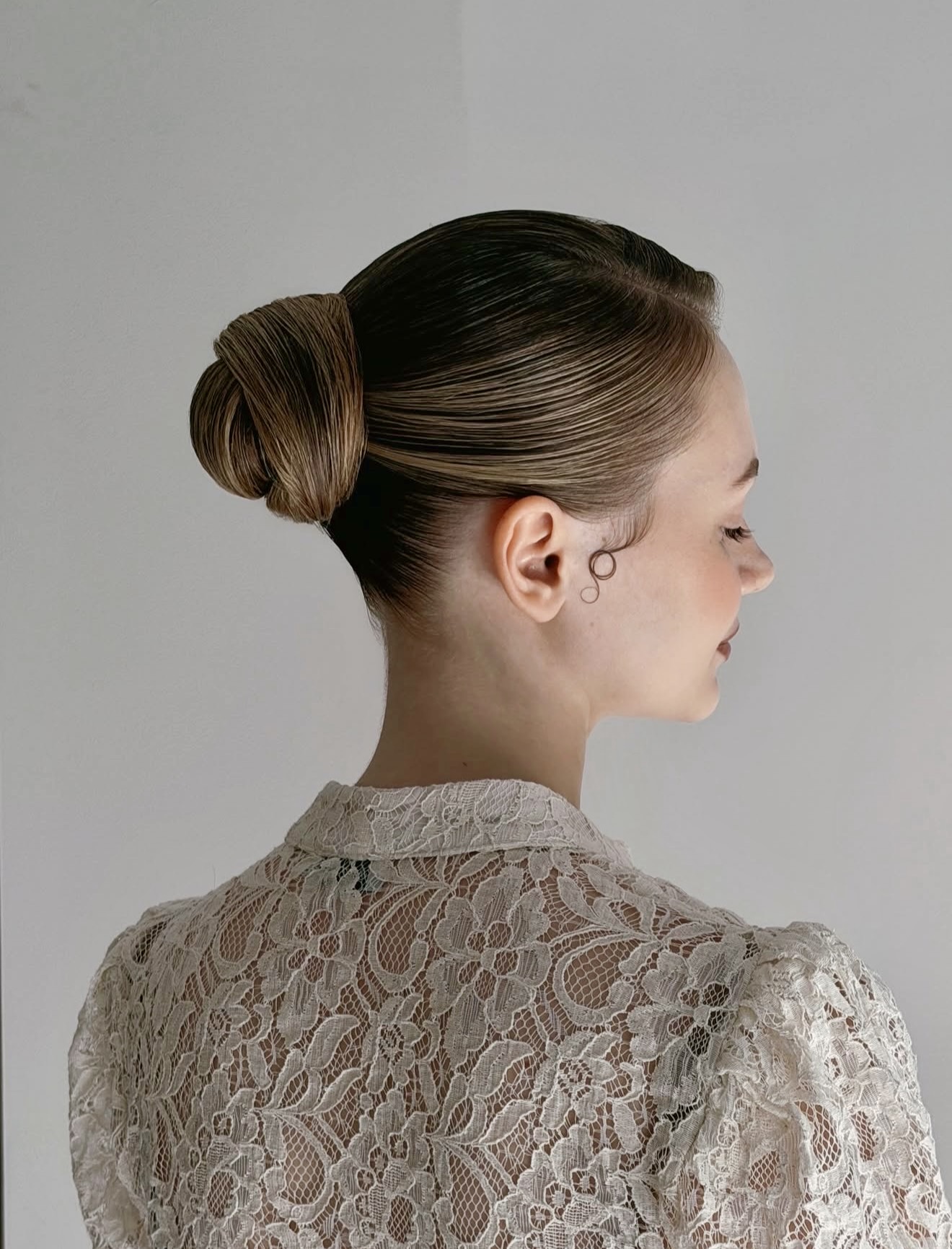 Sleek Low Bun With Face-Framing Pin Curls