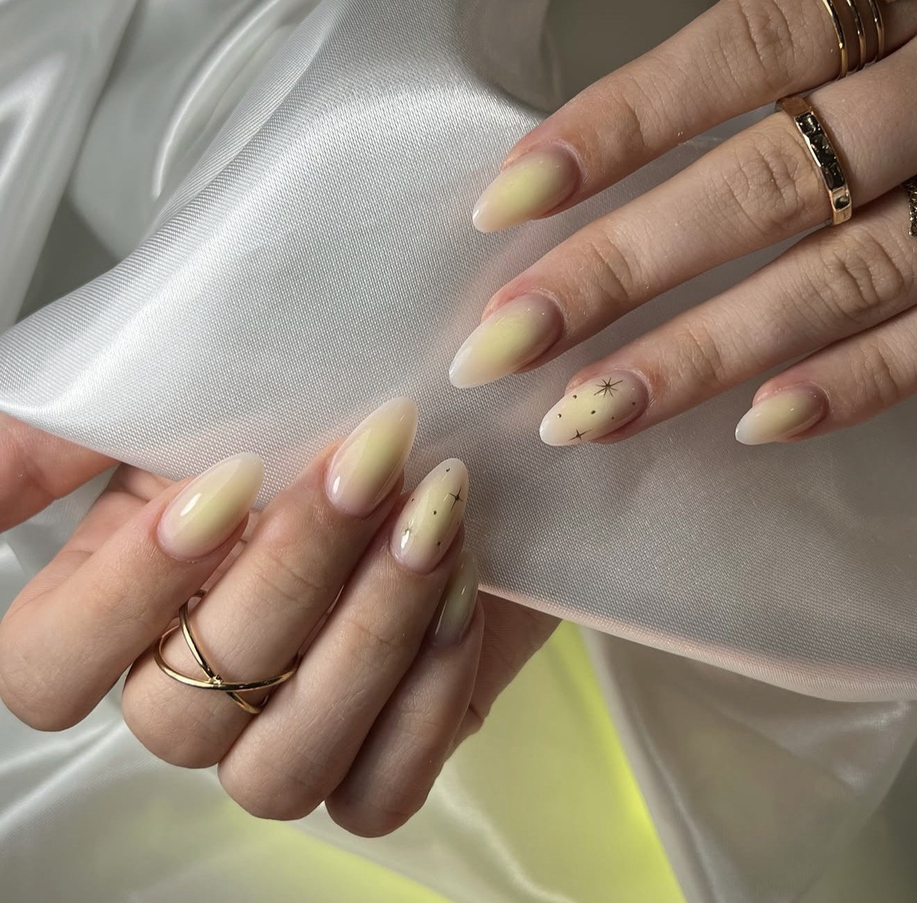 Subtle Yellow Aura Almond Nails with Star Accents